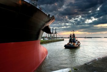 Tug boat taking out the ship from the harbor